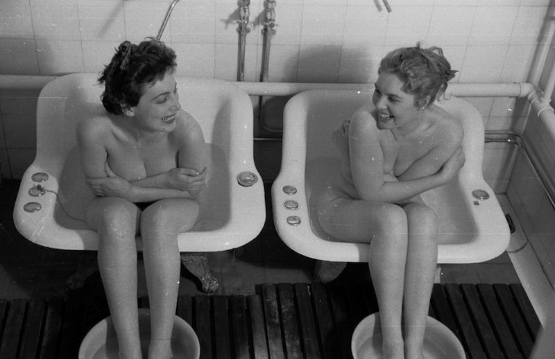 26th June 1954: Two girls sharing the ordeal of a nine-day diet at a health farm take one of their regular baths. The baths are alternately hot and cold to improve circulation. Original Publication: Picture Post - 7187 - Slimming Match - Blonde V Brunette - pub. 1954 (Photo by Maurice Ambler/Picture Post/Getty Images)